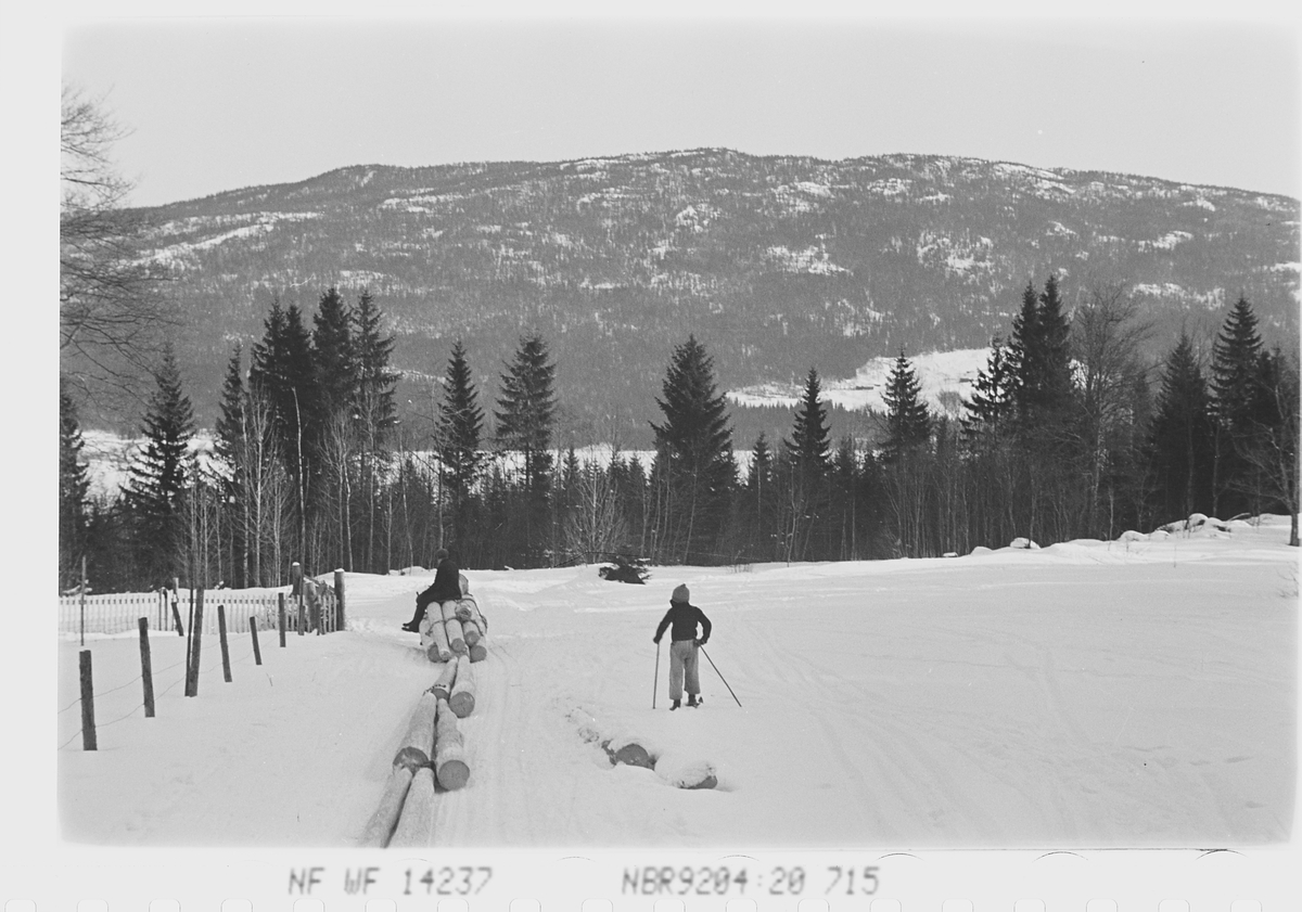 Tømmersanking og barn på ski om vinteren, Noresund, Fotografert 1941.