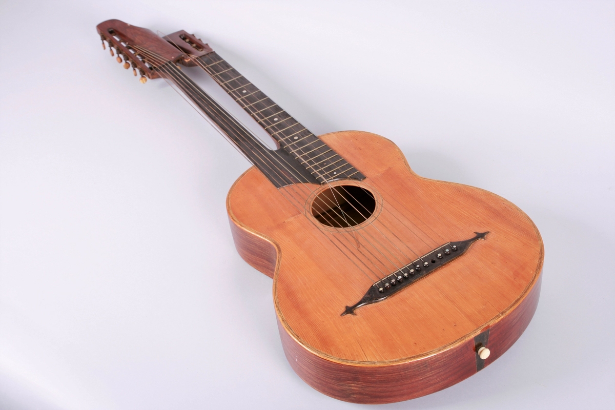 Gitar med dobbel hals. En hals med bånd og 6 strenger, 6 løssvingende strenger ved den andre halsen.