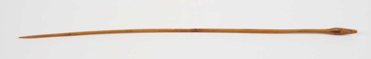 Èin strikkepinne i tre. Spiss i eine enden, og med eit "hovud" i andre.