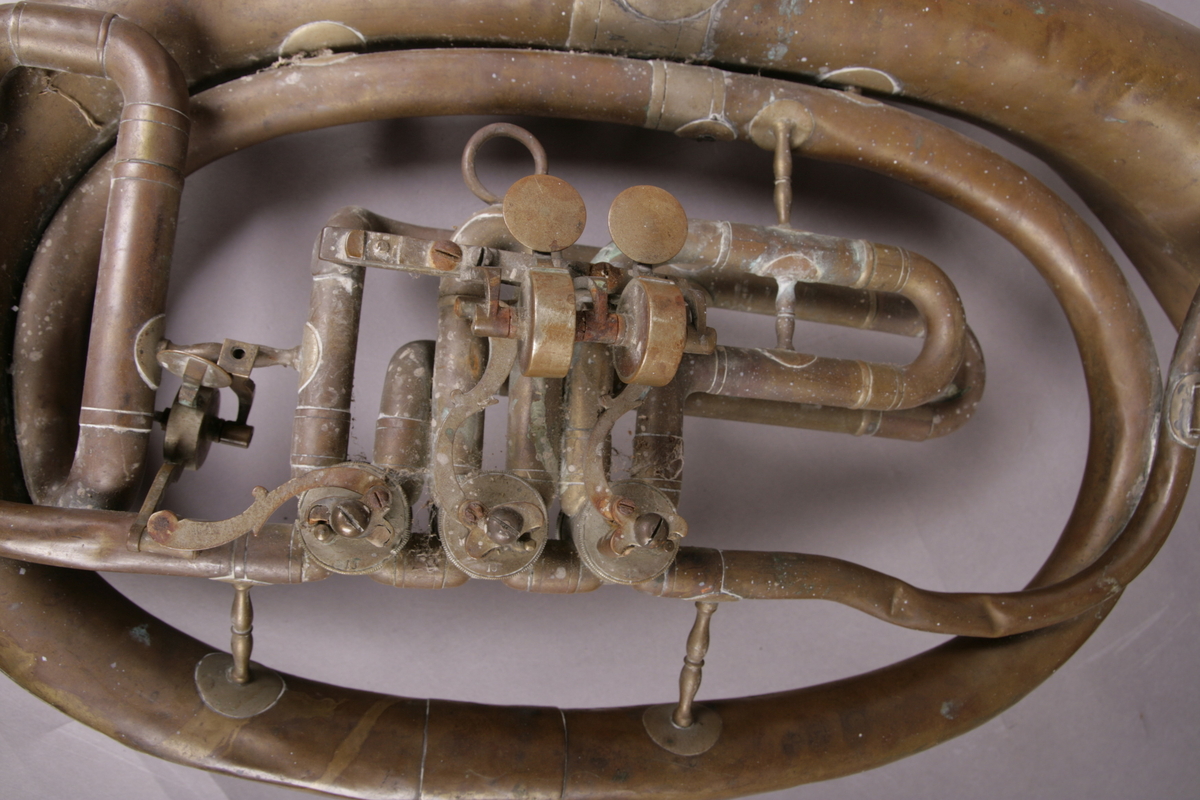 Blåseinstrument i metall med klaffer og ventiler.