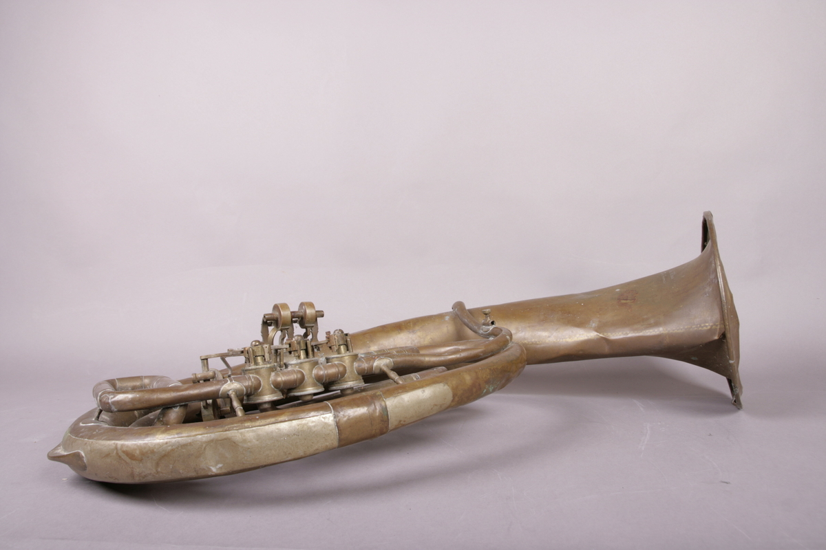 Blåseinstrument i metall med klaffer og ventiler.