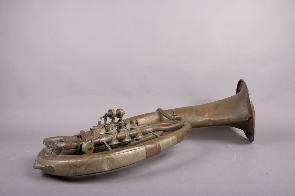 Blåseinstrument i metall med klaffer og ventiler.