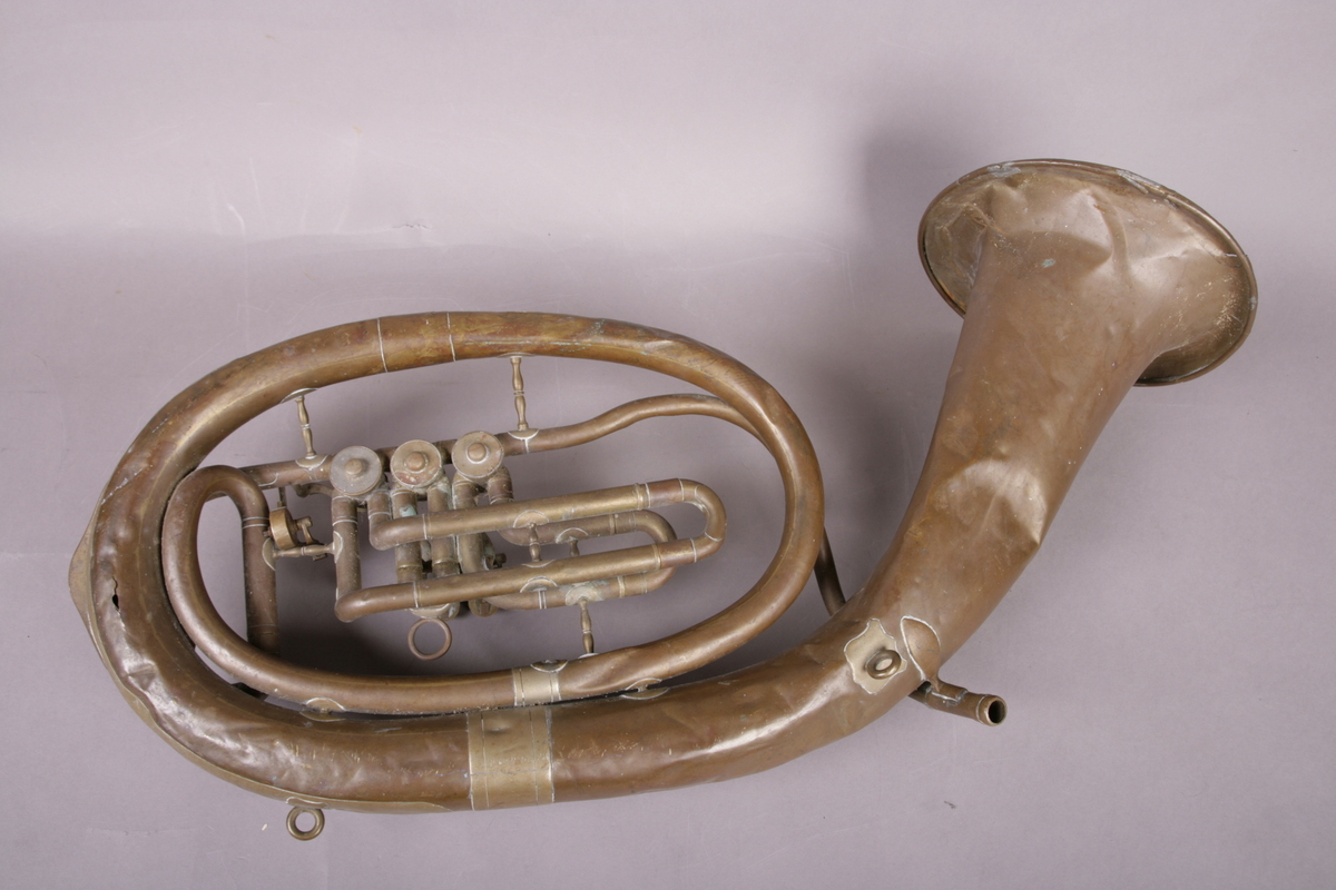 Blåseinstrument i metall med klaffer og ventiler.