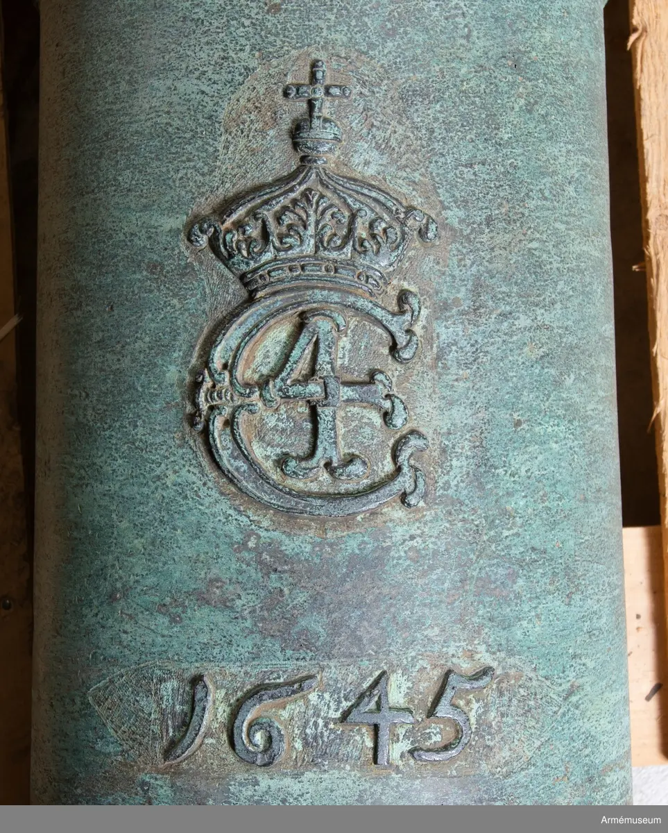 Grupp AI.
Med Kristian IV:s namnchiffer och därunder gjutåret 1645; å kammarbandet inskriften: FRANCISCUS. ROEN. ME. FECIT. GLYCKSTADT (Frans Roen gjorde mig i  Glückstadt). Loppets relativa längd: 21 kal. Kaliber: 9,8 cm. Vänster tapp märkt "8", kammarstycket "1646".