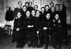 Gruppbild av flygtekniker vid vicekorpralskolan på F 7, 1942. 17 unga män på ett logemente.