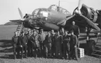 Grupporträtt av flygvapenpersonal samlade nedanför flygplan Saab B 18 efter färdigställd reparation efter haveri vid Fyllebro utanför Halmstad, 1940-tal.