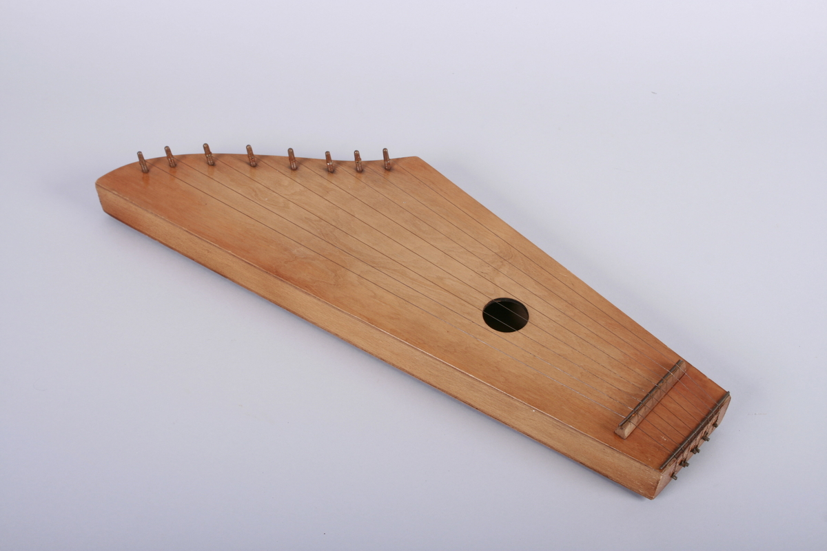 Kantele med åtte strenger. Rundt lydhull.