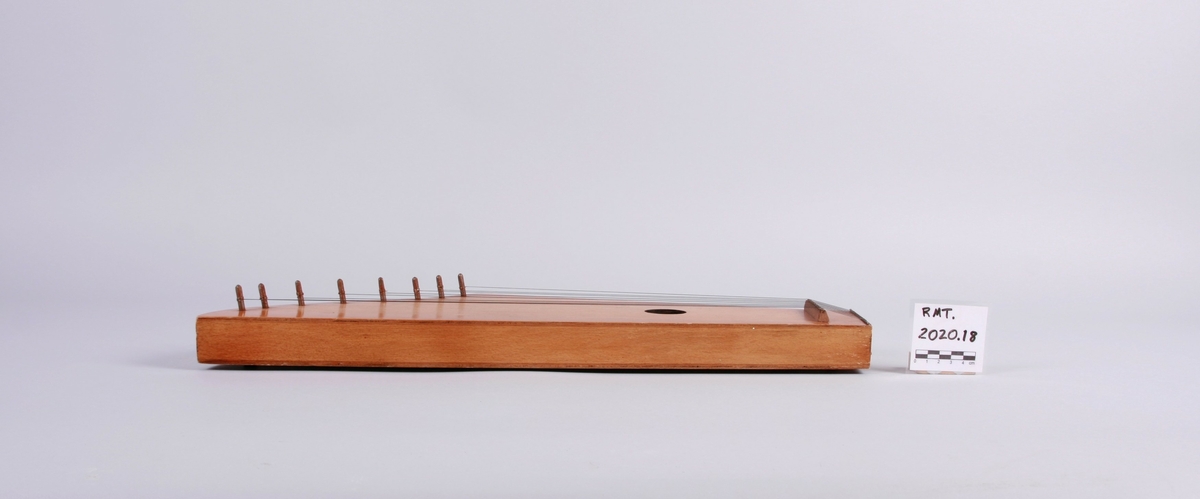 Kantele med åtte strenger. Rundt lydhull.
