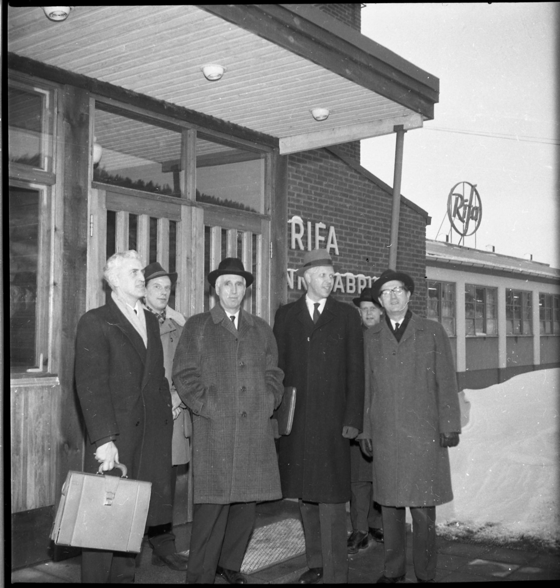 Sex män i hatt och ytterkläder står utanför entrén till Rifa-fabriken i Gränna. De är från vänster: K Mörner, B Arding, A Nordenstam, T Skytt, L Almén samt B Gråberg.