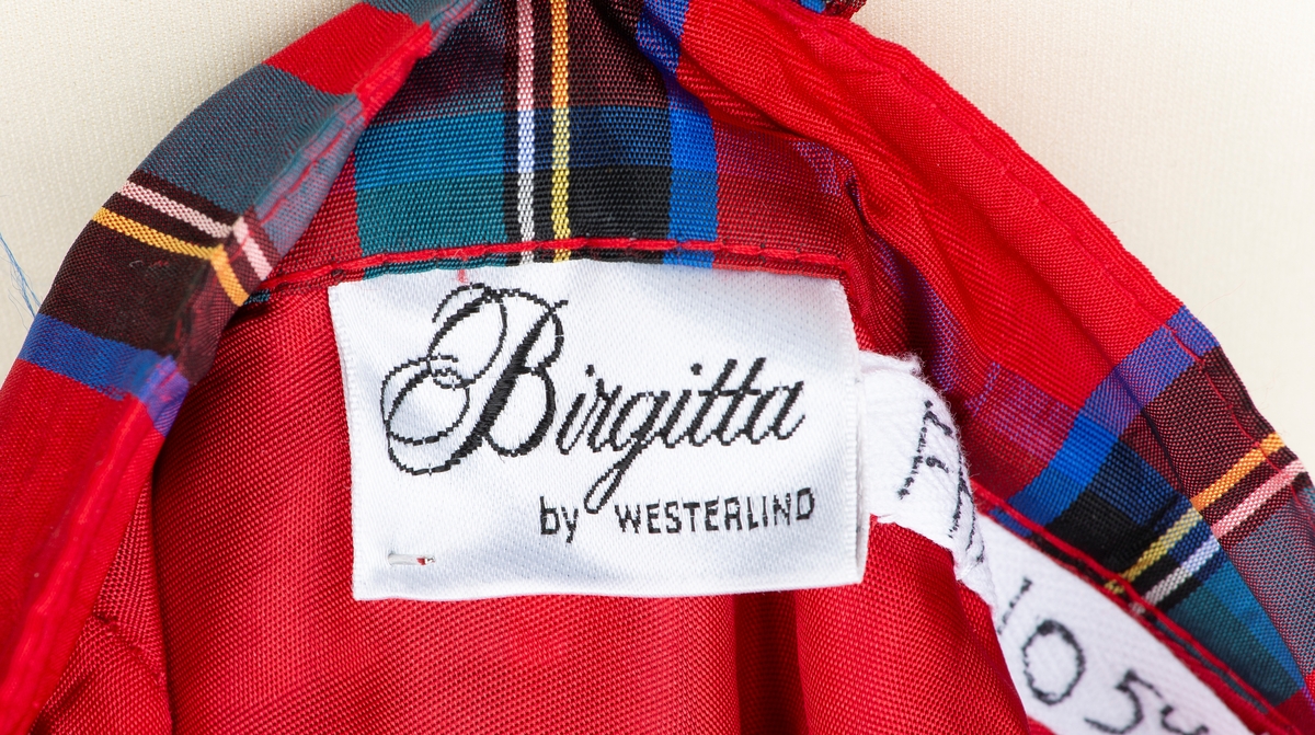 Halvlangt skjørt. Konfeksjonssøm. Merket "Birgitta by Westerlind" Sverige
Skotskrutet med løse folder ved linning. Helforet og 2 brede kapper nederst