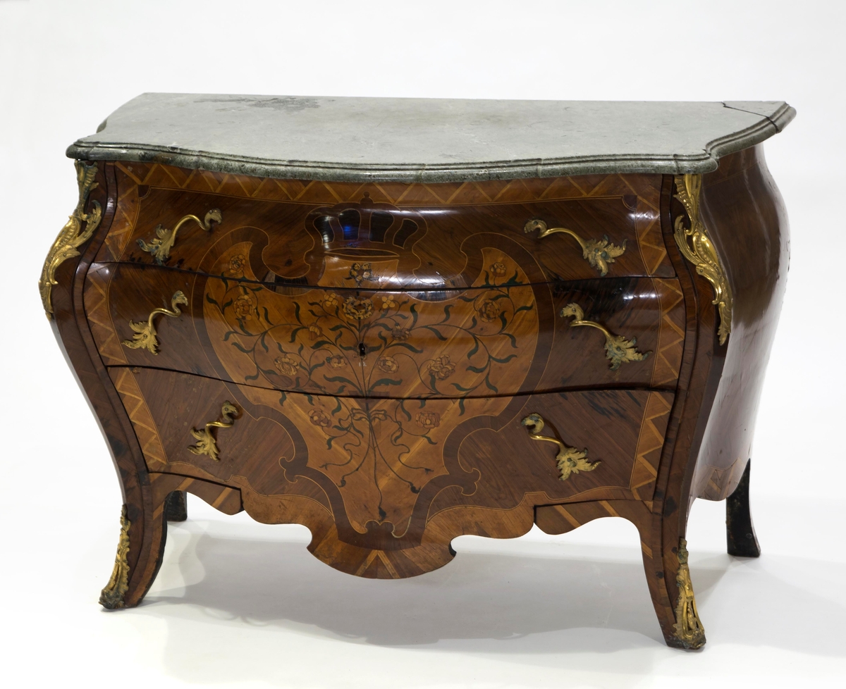 Intarsia  formet som et skjold med krone, og sammenflettede blomstergrener på skjoldet.