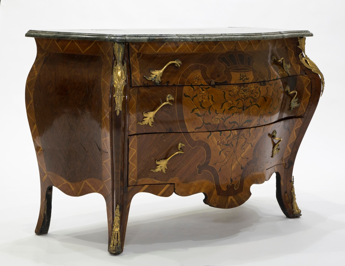 Intarsia  formet som et skjold med krone, og sammenflettede blomstergrener på skjoldet.