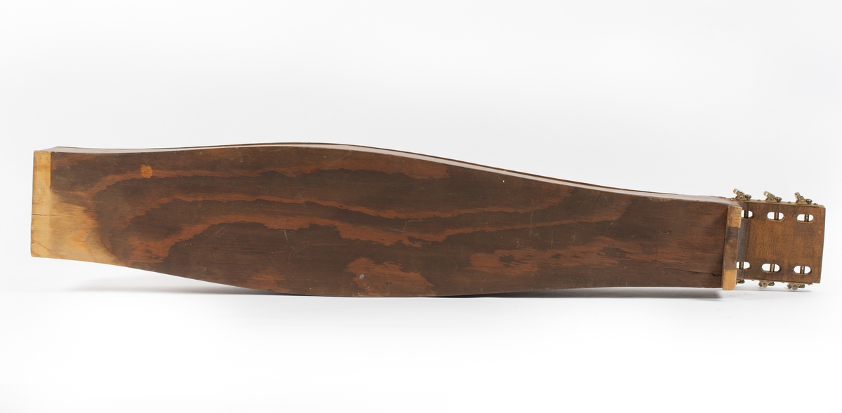 Utbuktende kropp med konvekse sidestykker. Skruekasse med rett brett i forlenging av kroppen. Seks stemmeskruer (gitar/mandolin-skruer) av metall. Tverrbjelke under lokket, synlig gjennom lydhull. Enkelt f-lydhull og et hjerteformet lydhull. 15 tverrband (mangler). 13 noter ved siden av f-lydhull. D-dur. Notesadel oppe og nede (mangler). Strenger (mangler): 1 melodi, 5 bodun. Vurdert strengefeste, ni hakk på notesadel nær stemmeskruene, fem på nedre ende. Fire metallfester på nedre endevegg. Ben oppe og nede (mangler). 
Lite eller ingen bruksmerker/slitasje etter spill.