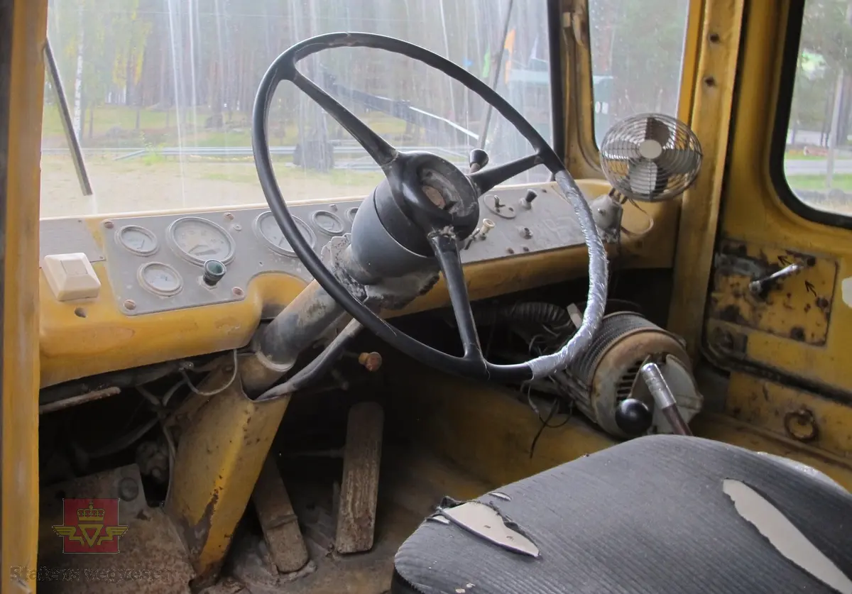 35 tonns gul dumper med 6 hjul, 2 akslinger. Tvillinghjul på bakaksel. 6-sylindret 14,6 liters Caterpillar dieselmotor som yter 400 hk. Dumperkassen har et volum på 17,8 m³. Skiltplater med serienummer 99F986 plassert på rammen og motoren. Metallplater fra produsenten med smørekart og advarsler. Hytte og motordeksler er i glassfiber. Dumperens toppfart er på 69 km/t.