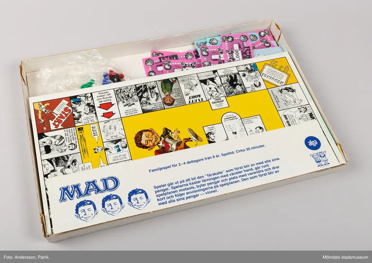Brädspel i rektangulär pappkartong. På utsidan syns karaktärer från den tecknade serien Mad. Spelet är ett familjespel för 2-4 deltagare från 8 år. Tillverkningsår 1979.