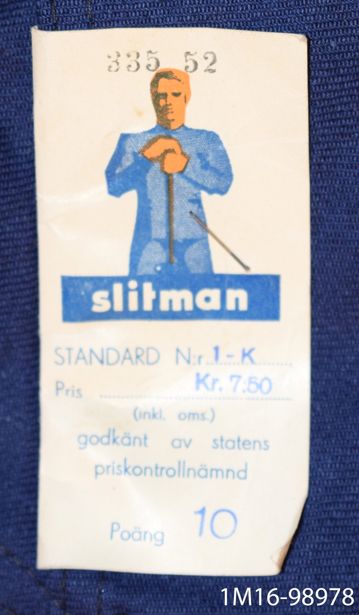 Herrbyxa - blå med två stora fickor fram. Bakficka. Sleif bak med metallspänne. Metallknappar i midjan för hängslen. Gylfen knäpps med fyra metallknappar. 
Upplagda byxben (för hand) Nya.
Märkeslapp medföljer med texten: Storlek 52. Inköpspris: 7.50 Kr.