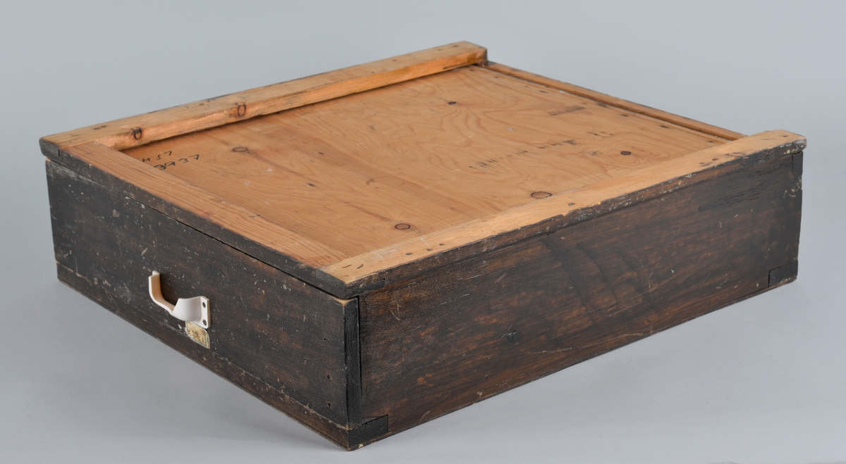 Trekasse for oppbevaring av rasjoneringskort, brukt under og etter andre verdenskrig.
Kassen har en uttrekkbar skuff med flere rom som passer til åpningene i fronten. Håndtaket på skuffen er delvis knust.
Kassen har 12 åpninger i 4 rekker, der det er påmalt tekst: 
1 rekke: X -  X - X 
2 rekke: X - X - kakao
3 rekke: lær - sko - kaffe
4 rekke: mel - fett - sukker