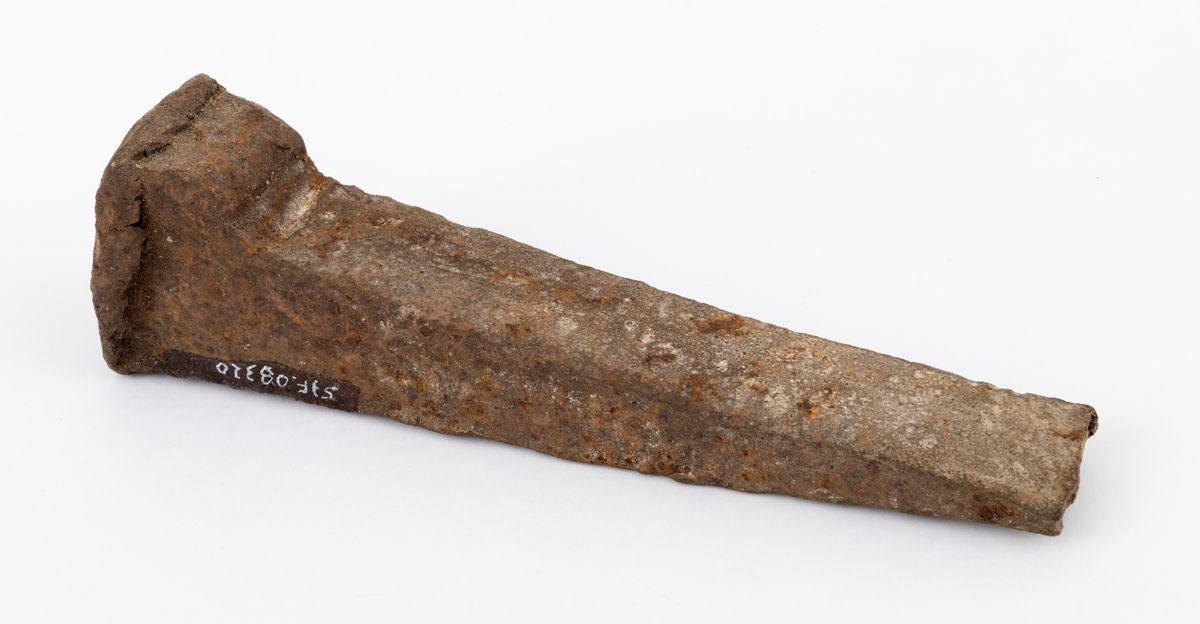 Jernkile som skal ha vært brukt under kløyving av ved til dampmaskinen på slepebåten Trysilknut på Osensjøen i Hedmark før den ble ombygd til dieseldrift (1958). Ifølge en av veteranene i dette fløtermiljøet, Birger Skavern (1922-1991), fortalte at alle vedkabber som hadde mer enn 4 tommers diameter måtte kløyves. Kilen er 18 centimeter lang, men eggen later til å være brukket. Den er svakt buet i lengderetningen og har et rektangulært tverrsnitt. Nakkepartiet er forsterket og har "skjegg" langs ytterkantene etter mange hammer- eller sleggeslag.