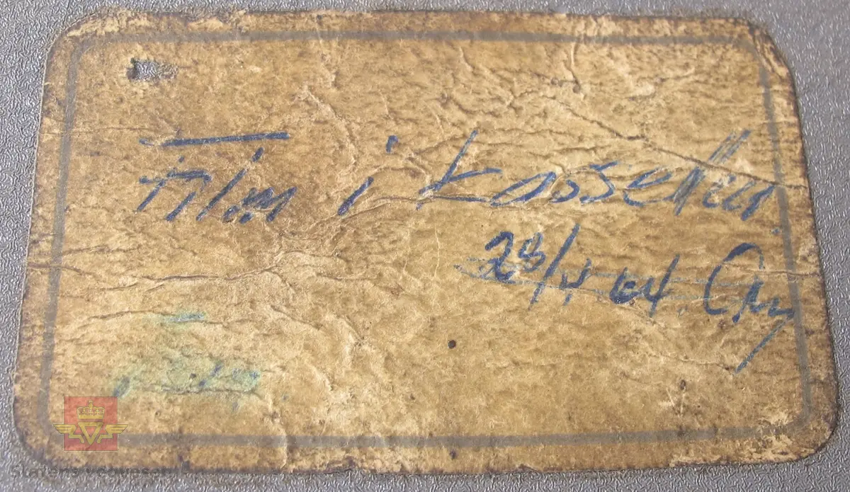 Oscillograf i oppbevaringskasse av treverk, med bærehåntak og låsekasse med nøkkel. Oscillografen er i grålakkert metall med skiltplate som har innskriften MIDWESTERN INSTRUMENTS MOD. 560 SER. 543 DATE 8 - 58 TULSA, OKLA. U. S. A. Den har utgående ledninger som er samlet i en gjennomsiktig gummistrømpe, og i enden sitter det en kobling i plast med 12 tilkoblingspunkter. Klistremerke på toppen med håndskriften Film i kassetten 28/4-64. Oppbevaringskassen er merket med skilt som har innskriften 12 KANALS OSCILLOGRAF KRAFTFORSYNINGENS SIVILFORSVARSNEMD, OSLO. Inni oppbevaringskassen ligger et papirark med håndskrift der det er skrevet ned når det er satt i ny film, og hvor mye film som er benyttet ved bruk, og hvor mange meter som gjenstår.