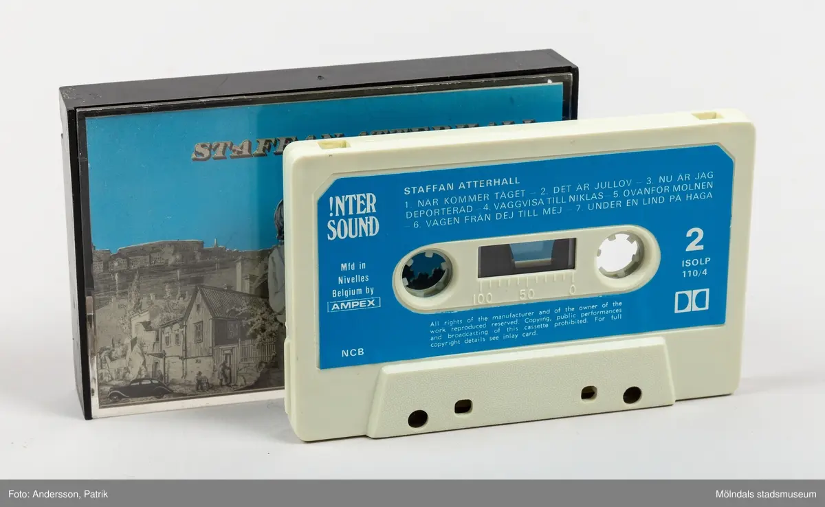 Ett kassettställ av hårdplast för förvaring av kassettband. Stället har en rund fot med manuell snurrfunktion. Kasettställets form är kvadratisk och färgen är röd. Ställets invändiga sidor är ljusgula. Hörnen har en vertikal sida med plast i träimitation. Kassettstället innehåller plats för 20 kassetter. I detta ställ finns 8 kassetter. På ställets ovansida finns en något upphöjd svart cirkel. Inuti cirkelns mitt finns en guldfärgad text med namnet Audio master.
Kassettband introducerades på marknaden 1963 av det nederländska teknikföretaget Philips. De användes för att spela in musik och talinspelningar. Kassettbanden var väldigt populära mellan 1975-1995.