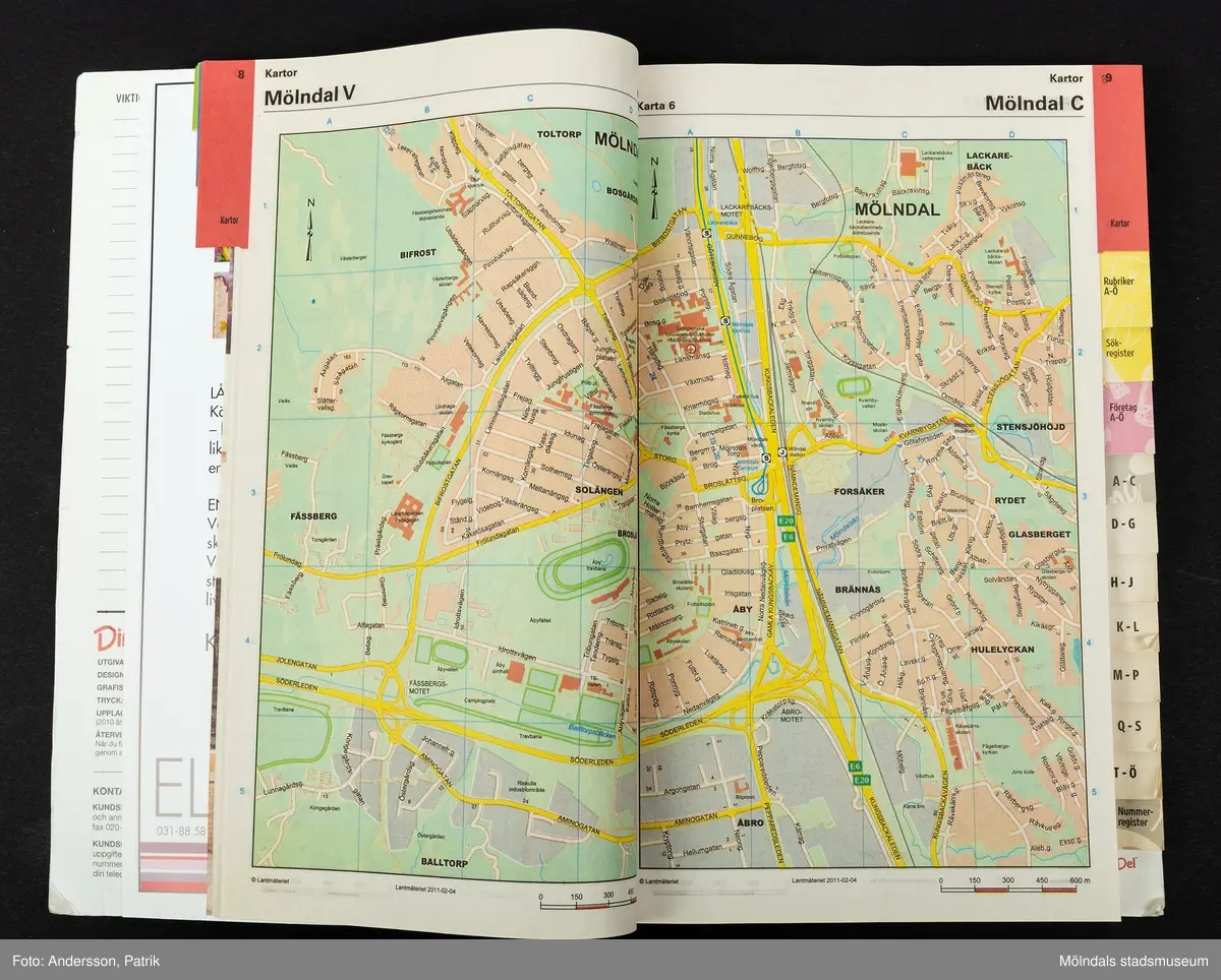 En rektangulär telefonkatalog. Katalogen är grön och har texten Din Del tryckt i i röd färg uppe i högra hörnet. Under Din Del finns texten Mölndal, Kållered, Mölnycke,Landvetter Lindome, 2011 tryckt i vit färg. På nedre delen av katalogen finns sex mindre rektangulära rutor med reklaminnehåll. Den gröna delen av katalogen har ett stiliserat mönster i mörkare grön färg i form av flygplan, skor, blommor och ankare. Telefonkatalogen Din Del var en lokal variant av telefonkatalogen och tillverkades av Eniro. I katalogen finns lokala telefonnummer till privatpersoner, samhällsinrättningar och företag. Din Del började ges ut på nätet i början på 90-talet. De fysiska katalogerna som delades ut till hushållen, slutade tillverkas 2016, då det inte var lönsamt längre att tillverka den.