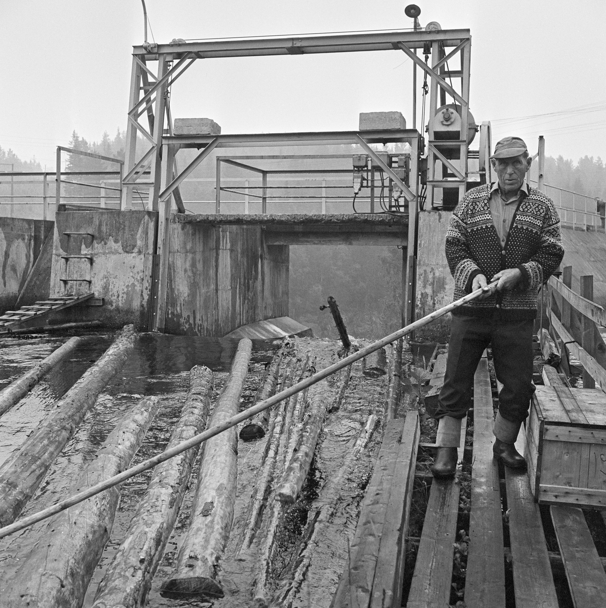 Fløting i tømmerrenne forbi E-veksdammen, Evenstad, Arendalsvassdraget 30/8 1970. Fløtere med fløterhaker. Lenseanlegg.