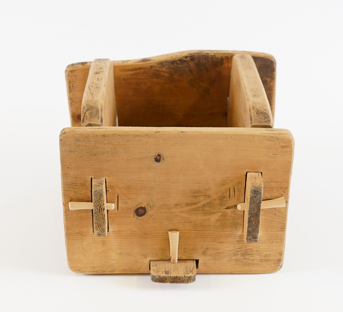 Smørform i tre. To av sidene, samt botnen, har utstikkarar på sidene, medan dei to andre har hol. Forma vert sett saman til ei kasse ved å setje utstikkarane inni hola. Gjennom utstikkarane er det sett i trepluggar, for sikring.