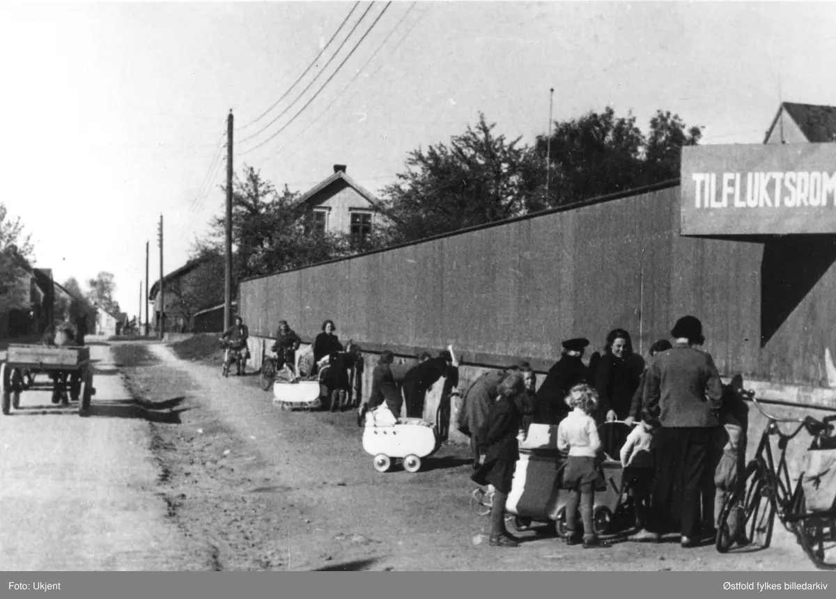 Noen kikker gjennom plankegjerdet for å se på de arresterte i Sarpsborg  i fredsdagene i mai 1945.
