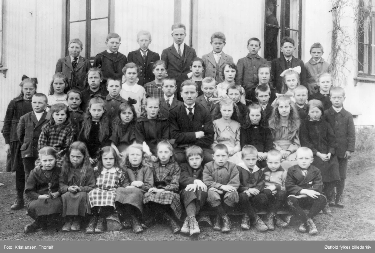 Hvammer skole i Trøgstad 1922 med læreren Gustav Hagen. Navneliste med plassering se bakside fotokort.