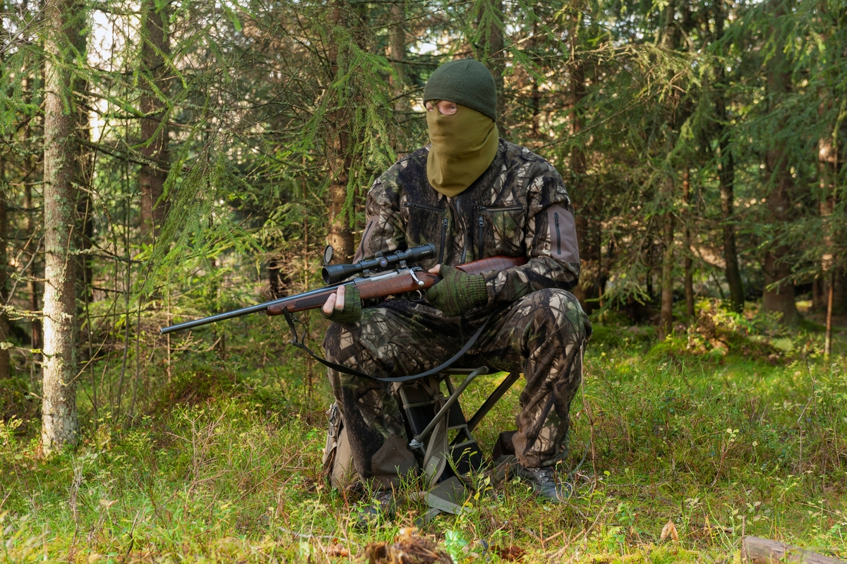 Jeger på post under høstjakta. Posten er plassert nær der man tror viltet kommer, gjerne nær dyrestier eller kjente trekkruter for viltet. Posten er plasseert i tett skog med fri sikt mot åpent terreng. Jegeren bruker en lydløs smygdress av merket Swedish Chasseur Predator Ursus som er utviklet av Rasmus Boström og Jonas Lännbjer. Det finnes også kamuflasjedrakter fra andre produsenter på markedet. Når det er mildt om høsten er det vanlig å sitte uten ansiktsmaske. Jegeren er utstyrt med børse. Han har med seg en jaktradio og Garmin GPS. Jeger: Jan Ove Fuglebrenden fra Løten. Bildet er arrangert. 