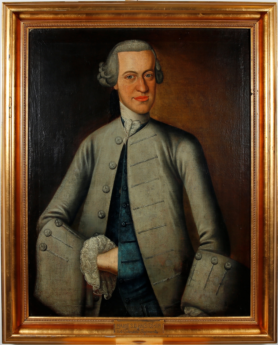 Portrett av mann en face trekvart profil. Kledd i grå krageløs frakk med ermeoppslag. Grå knapper trukket i samme stoff på ermer og frakk. Blå vest i brokade med knapper trukket i samme stoff og lommer. Hvitt halsbind med blonde, og hvit blondekant ved høyre erme. Grå parykk med hestehale. Høyre hånd stukket inn i vesten. 