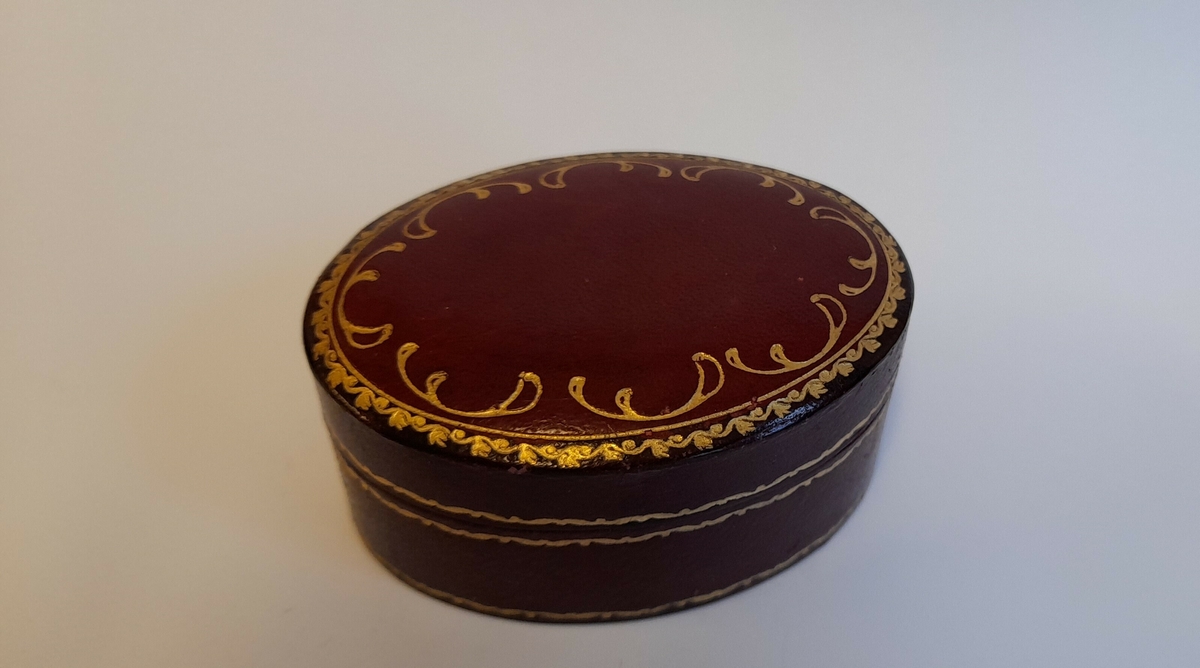 Dalar med kjede.. Frå mynten heng tre mindre myntar med skålar og trekanta lauv.
Mynten har monogram til Christian 5 (1670.1699) og er prega i 1679
Kjedet ligg i eit ovalt hus, trekt med raudt skinn med gulldekor.