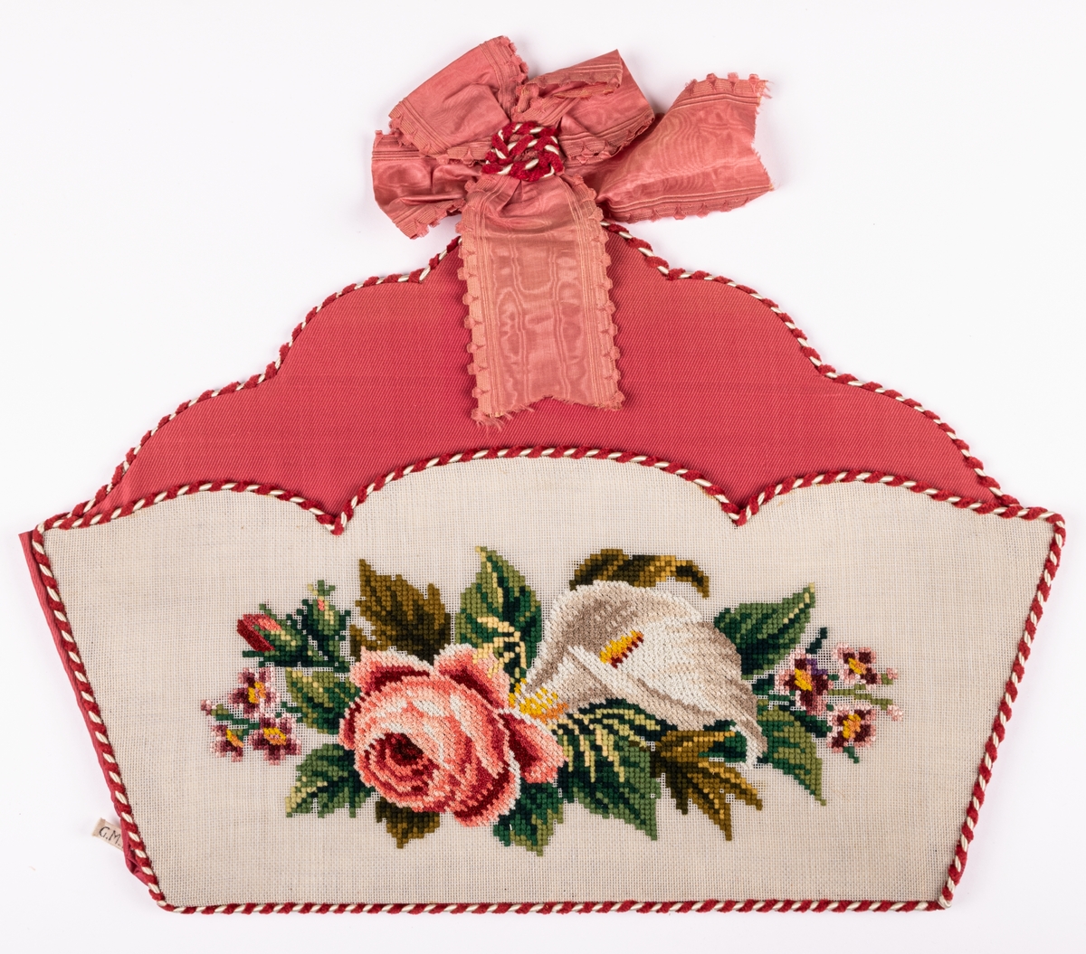 Handskkorg att hänga på väggen, broderad på stramalj, fodrad med rosa siden och kantad med röd och vit snodd.