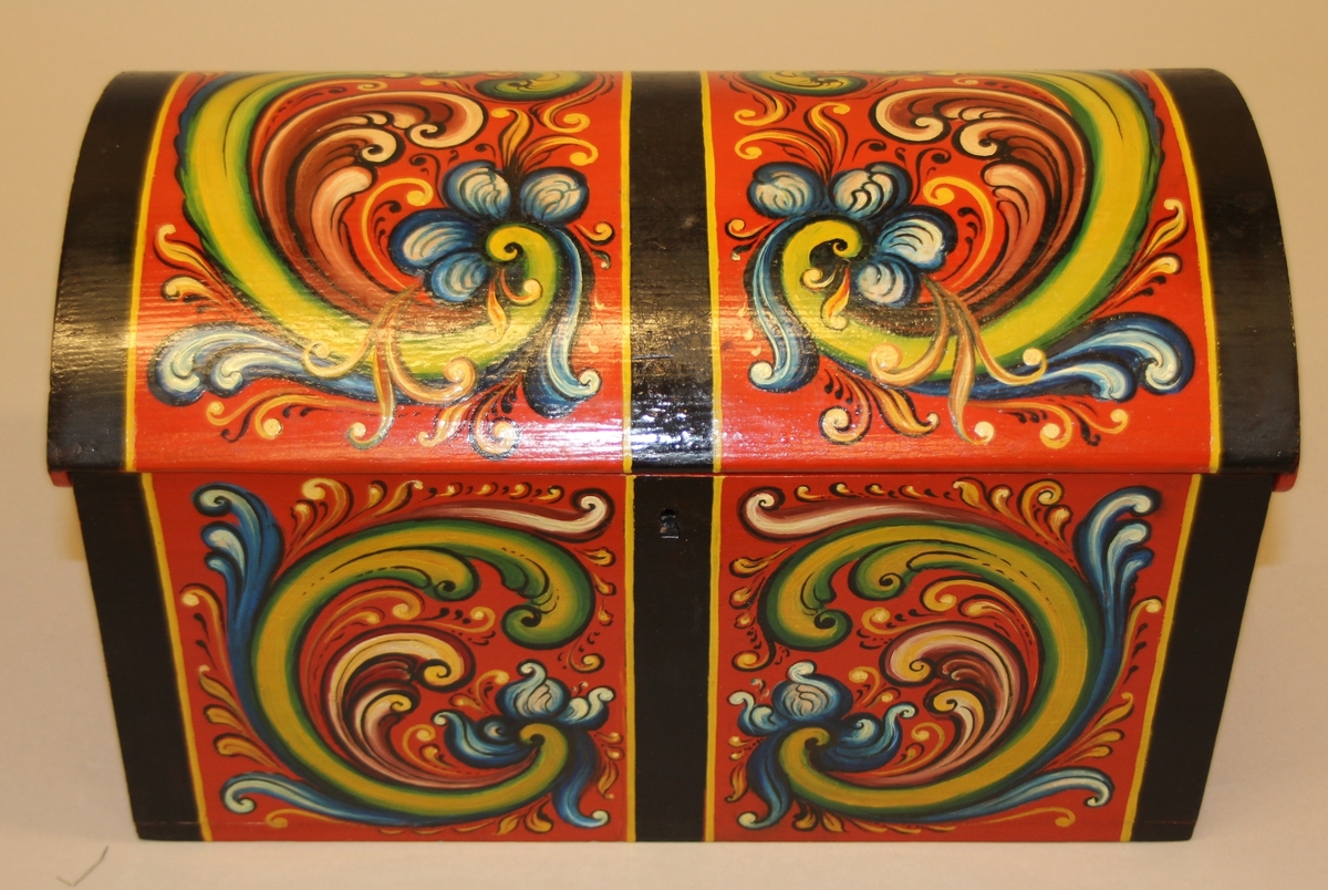 Rosemåla. lita kiste i klare fargar. Tydlege C-krullar både på loket og framme, desse er ramma inn med svarte, måla band.Raud botnfarge. Einsfarga sider og bakside. Umåla under botn. På Baksida er det måla DALEN.  Inni har kista eit lite rom på den eine sida. Grønmåla inni. Kuva lok. Lås med nøkkel.