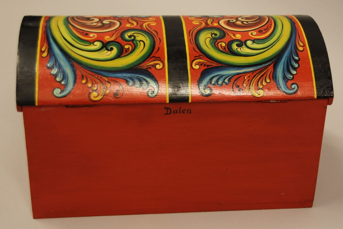Rosemåla. lita kiste i klare fargar. Tydlege C-krullar både på loket og framme, desse er ramma inn med svarte, måla band.Raud botnfarge. Einsfarga sider og bakside. Umåla under botn. På Baksida er det måla DALEN.  Inni har kista eit lite rom på den eine sida. Grønmåla inni. Kuva lok. Lås med nøkkel.