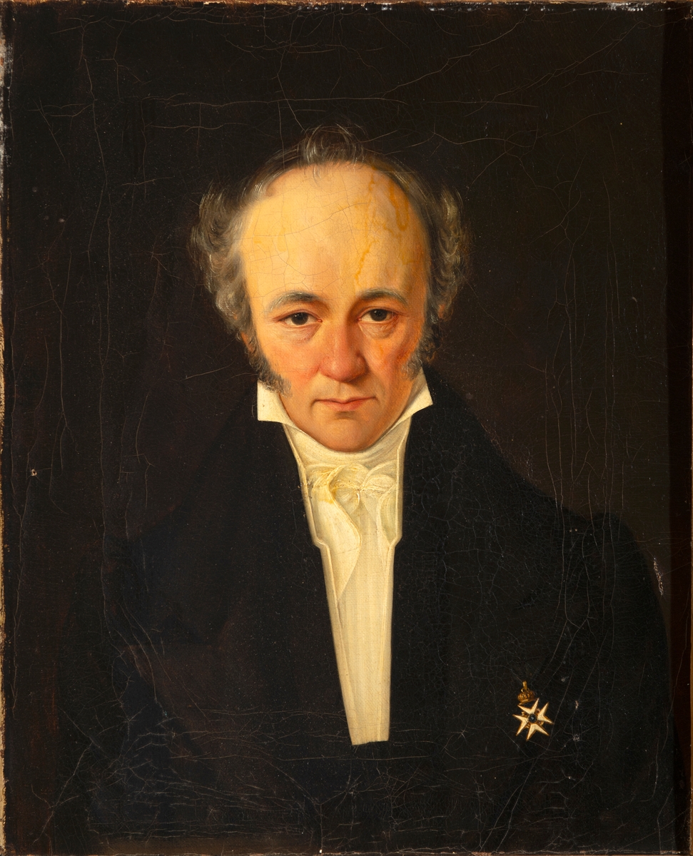 Portrett av Jakob Nicolay Roll. Brystbilde en face. Grått hår og skinnskjegg. Kledd i mørk jakke med bremmer. Hvit skjorte med stående krage og knyttet halstørkle. St. Olavs Orden på hans venstre bryst. Mørk bakgrunn. 