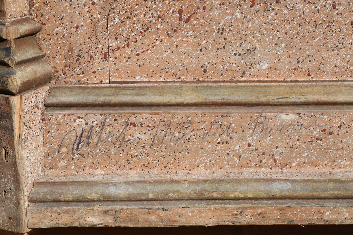 Prekestol (a), fot (b) og (c og d) et dekorelement formet som en flamme, fra Aas kirke, Bøverbru. Sekskantet prekestol med en innebygget plate for å plassere bibelen langs framsiden. Hver side har speil som er blåmalt i marmoreringsteknikk, mens resten av hver vegg er malt rosa med prikker i dekorasjonsmaling som imiterer en annen steintype. Påskrift nede på prekestolen: "Uttatt 1915 fra Aas Bøverbru". Antatt tatt ut fra Aas kirke i forbindelse med brannen i 1915.