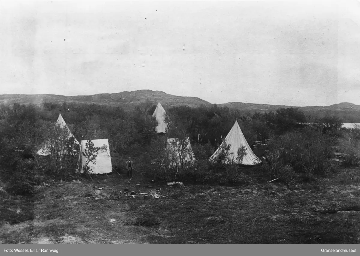 Telegrafarbeidernes leir ved Tangen bro, Kirkenes, 1897. Vi ser tre lavvoer, to telt og en mann står utenfor et av teltene.