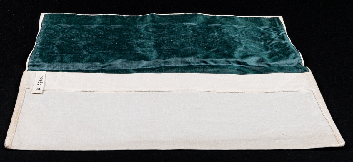 Servettväska i vitt linne med venetianskt broderi. Fodrad med grönt råsiden.