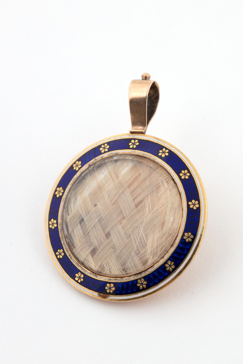 Medaljong med flettet hår og tørkede blomster inni.