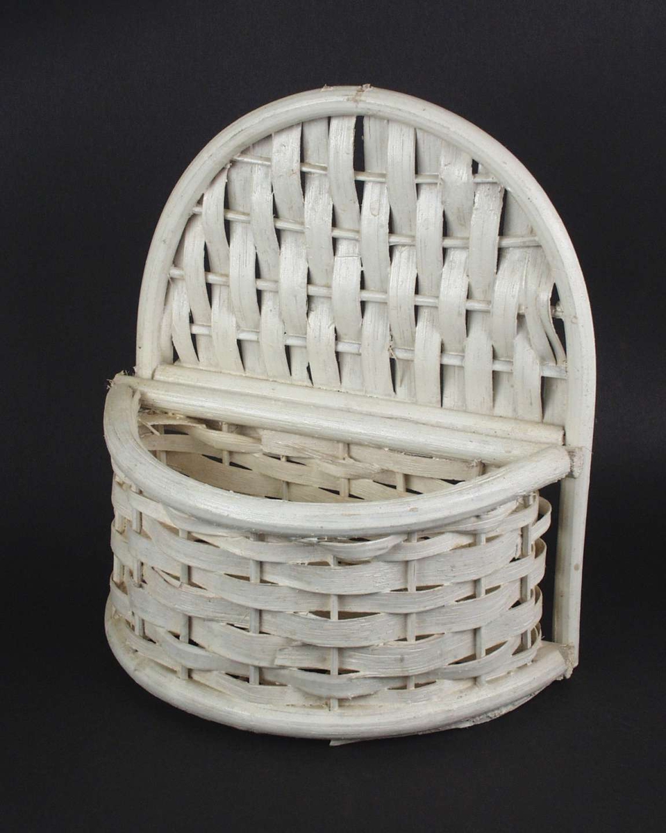 Hvit flettet kurv med buet rygg.