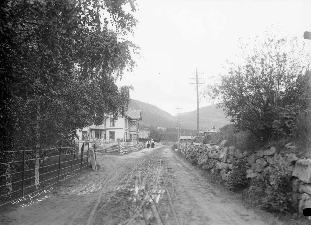 27.07.1908. Vinstra hotel og prestegård. Bygninger, vei, telefonstolper, steinmur, trær.