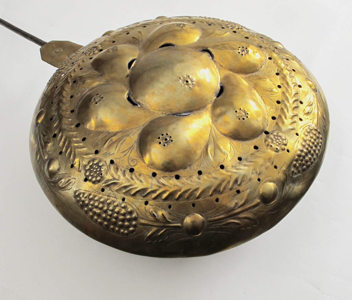 Sengevarmer.   messing.   Beholder rund. Lokk drevet med uthamrede ornament.  Under kanten jernring. Skaft jern.  Messing,   drevet, punslet og gjennombrutt arbeid,   innvendig fortinnet.  I lokket innvendig sees   kobber.  Midt på lokket en stor rund bule (eple?) med 6  pæreformete buler omkring, i mellomrommene mellom  pærene stiplete blad i lavere relieff. Langs kanten  en bladgren, ytterst med 4 kongleformer på gren med  blad. Sekskantet hengselbeslag med to messingnagler,  over det nederste utydelig stempel  Langt  jernskaft med to profilringer øverst.  På baksiden svakt synlige eierinitialer.  Skaftet går over i jernring rundt pannen., som har skrånende sider mot bunnen. RH.