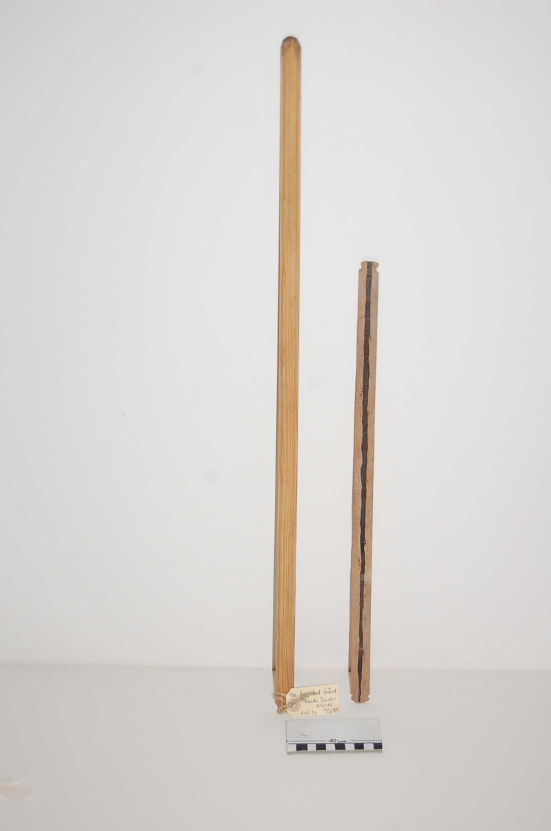 a;  flat under, overside tynnere kanter-3mm på hver side, buet i midten.
b, skarpe sider, buet over og underside, mørk, ujevn stripe p den ene siden. To hakk nær hver ende, endene lett krumme