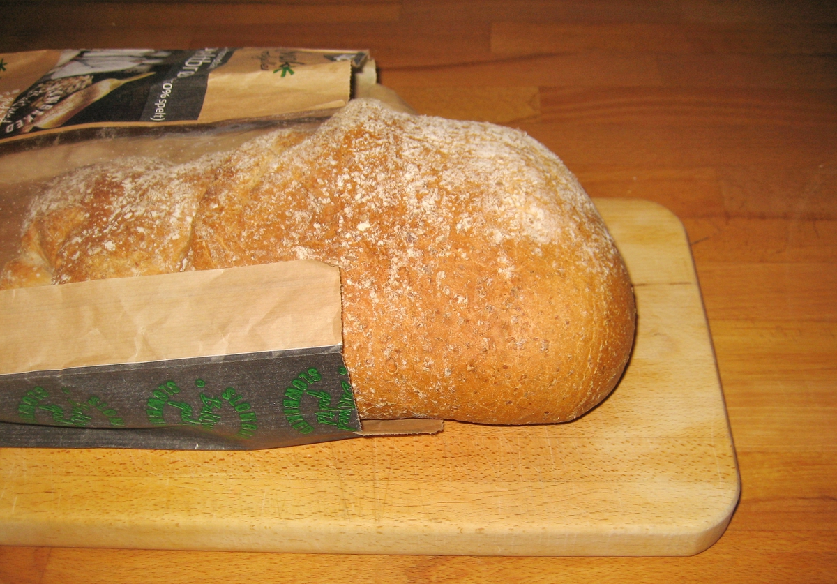 På brødposen finnes to motiv. Første motiv: To bakere som står med en ferdig deig. En ung og en eldre. Det ser ut som om den unge bakeren er under opplæring. Annet motiv: Korn og en gammel type redskap til å spa opp korn med.