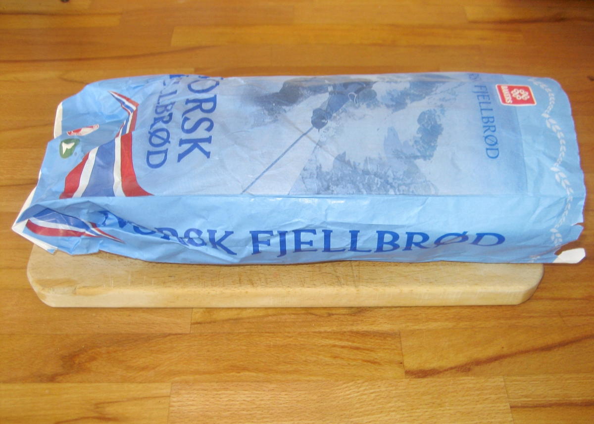 Motivet på brødposen er en skiløper som står nedover en fjellside. Han har på seg skijakke, en liten rygsekk og skibrille. Bak skiløperen ser man et kneisende fjell. Det norske flaggets farger rød, hvit og blått er lagt i en bølgende bevegelse under skiløperen.