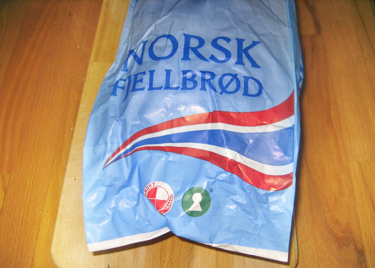 Motivet på brødposen er en skiløper som står nedover en fjellside. Han har på seg skijakke, en liten rygsekk og skibrille. Bak skiløperen ser man et kneisende fjell. Det norske flaggets farger rød, hvit og blått er lagt i en bølgende bevegelse under skiløperen.