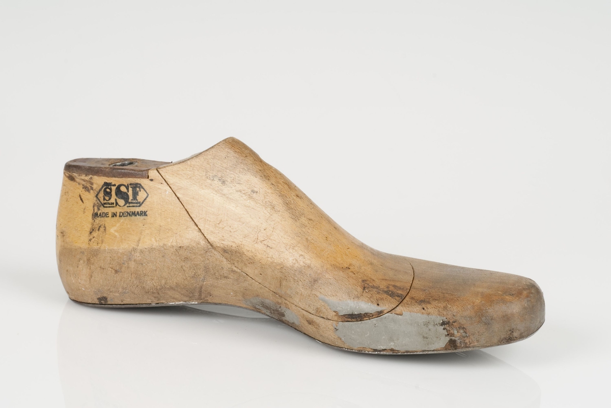 En tremodell i to deler; lest og opplest/overlest (kile).
Venstrefot i skostørrelse 42, og 8 cm i vidde.
Såle i metall.