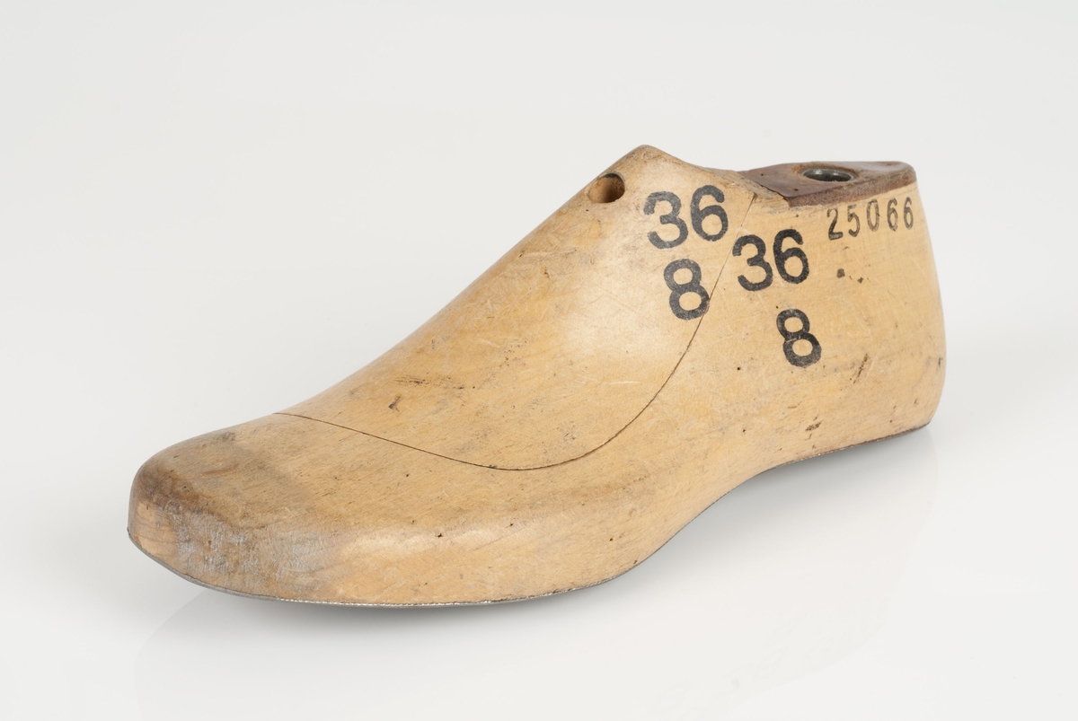 En tremodell i to deler; lest og opplest/overlest (kile).
Venstrefot i skostørrelse 36, og 8 cm i vidde.
Lestekam i skinn.
Såle i metall.