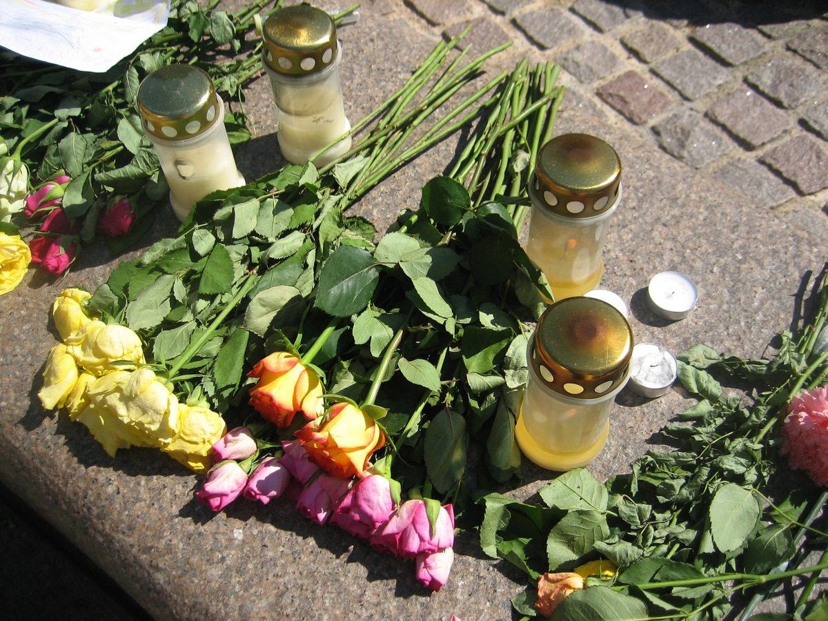 Minner etter terrorhandlingen den 22. juli 2011. Blomster, kort og lykter på fontene på Lillestrøm torg.